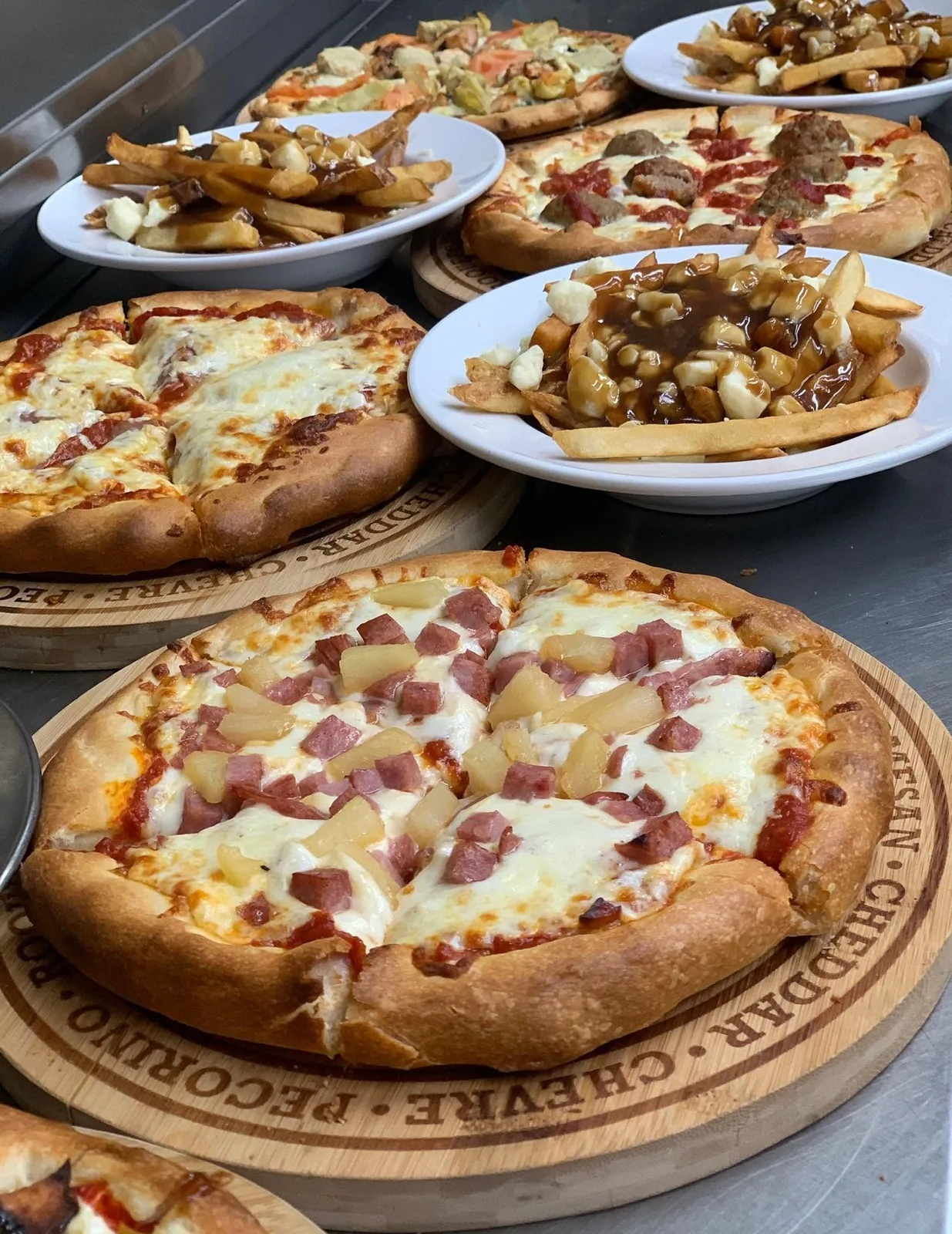 Pizzas et poutines servies sur planches de bois
